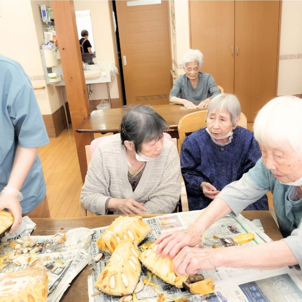 ジャックフルーツを切り分ける利用者さまたち