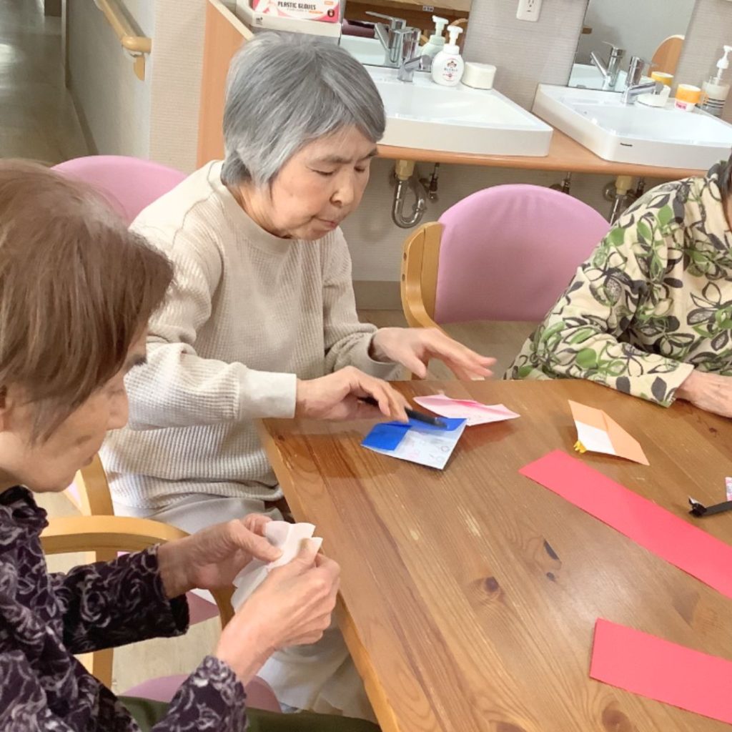 折り紙の雛人形を作っている利用者さまたち