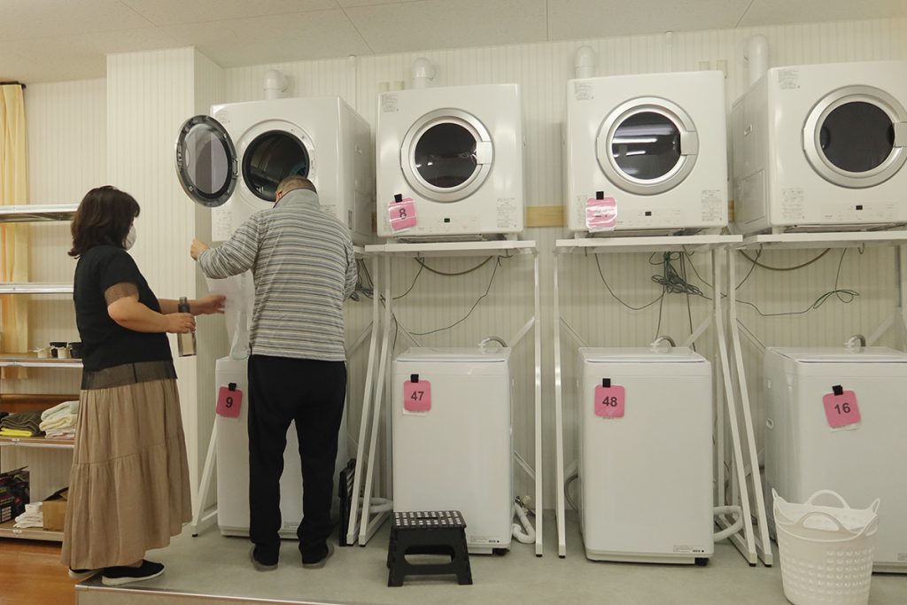 みのりあ北名古屋の洗濯機で作業を行うスタッフ